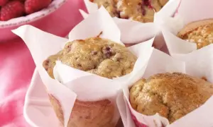Leckere protein muffins rezept mit Himbeeren, frisch gebacken und auf einem rosa Teller angerichtet.
