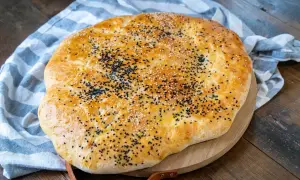 Goldbraunes Fladenbrot, bestreut mit Sesam und Schwarzkümmel, perfekt für ein einfaches Fladenbrot Rezept.