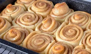 Frisch gebackene, gesunde Zimtschnecken in einer Backform. Sie duften nach Zimt und Zucker und sind bereit zum Genießen.