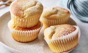 Saftige Muffins mit Quark, bestäubt mit Puderzucker, auf einem Teller arrangiert.
