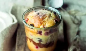 Saftiger Kuchen im Glas mit Beeren und Schokoschichten, bestäubt mit Puderzucker. Ein Genuss zum Löffeln!
