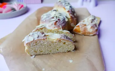 Süßer Hefezopf, frisch gebacken und mit Zuckerguss und Mandelsplittern verziert. Ein tolles Rezept für den Kaffeetisch.