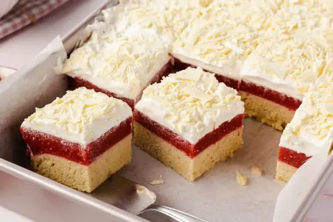 Schneeweiße Sahne und rote Fruchtschicht auf hellem Boden – dieser Frau Holle Kuchen sieht aus wie frisch aus dem Märchen!