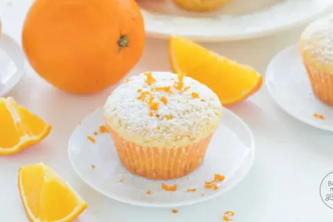 Fanta Muffins mit Puderzucker und Orangenschale, garniert mit frischen Orangenspalten. Ein süßer Genuss!