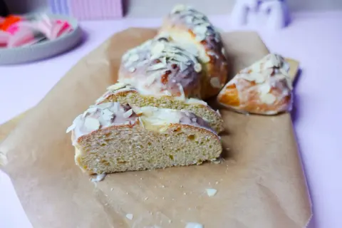 Süßer Hefezopf, frisch gebacken und mit Zuckerguss und Mandelsplittern verziert. Ein tolles Rezept für den Kaffeetisch.