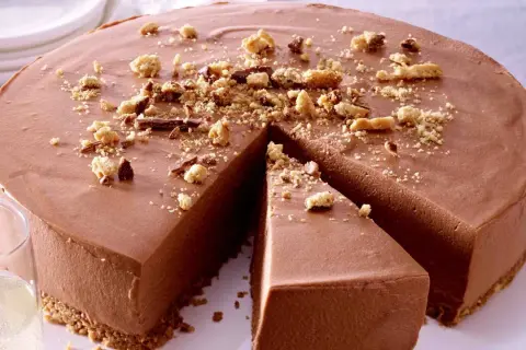 Schokoladenmousse-Torte mit Keksboden, bestreut mit Krümeln und Schokostückchen. Perfekt für einfache Torten-Momente.