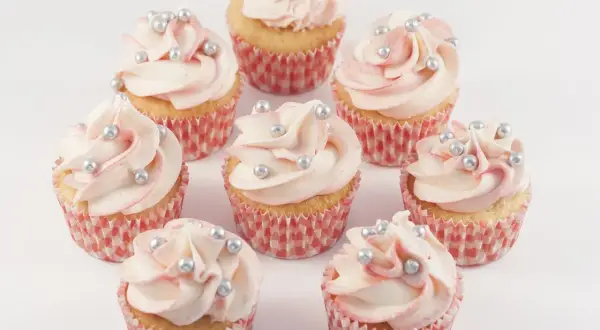 Mini Muffins mit zartrosa Frosting und silbernen Perlen, perfekt für ein mini muffins rezept.