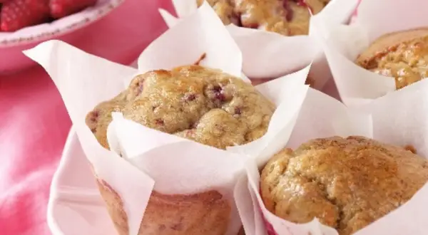 Leckere protein muffins rezept mit Himbeeren, frisch gebacken und auf einem rosa Teller angerichtet.