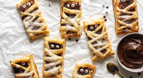 Leckere Mumien-Törtchen mit Schokocreme, ein tolles Rezept für Halloween! Mit Zucker bestäubt und lustigen Augen.