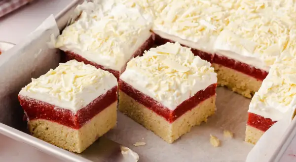 Schneeweiße Sahne und rote Fruchtschicht auf hellem Boden – dieser Frau Holle Kuchen sieht aus wie frisch aus dem Märchen!