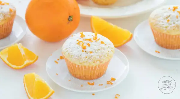 Fanta Muffins mit Puderzucker und Orangenschale, garniert mit frischen Orangenspalten. Ein süßer Genuss!