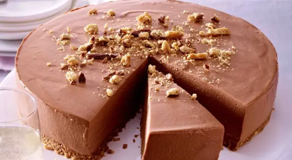 Schokoladenmousse-Torte mit Keksboden, bestreut mit Krümeln und Schokostückchen. Perfekt für einfache Torten-Momente.