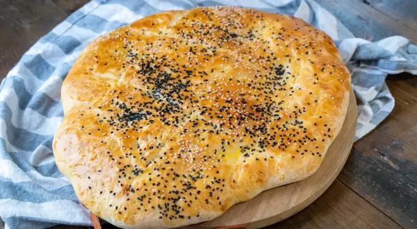 Goldbraunes Fladenbrot, bestreut mit Sesam und Schwarzkümmel, perfekt für ein einfaches Fladenbrot Rezept.