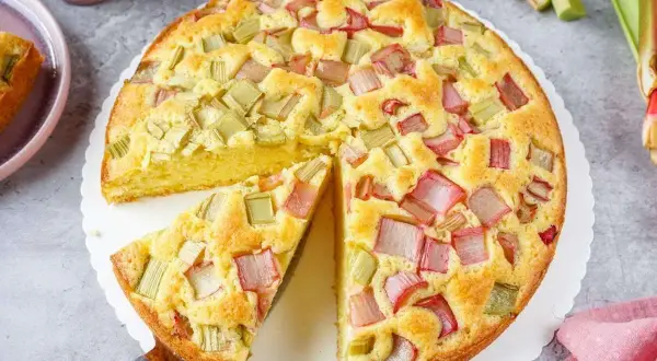 Ein saftiger, schneller Rhabarberkuchen mit vielen roten und grünen Rhabarberstücken, bereit zum Genießen.