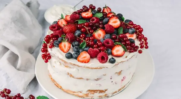 Himbeer Mascarpone Torte, üppig belegt mit frischen Beeren und Minze. Ein Fest für die Sinne!