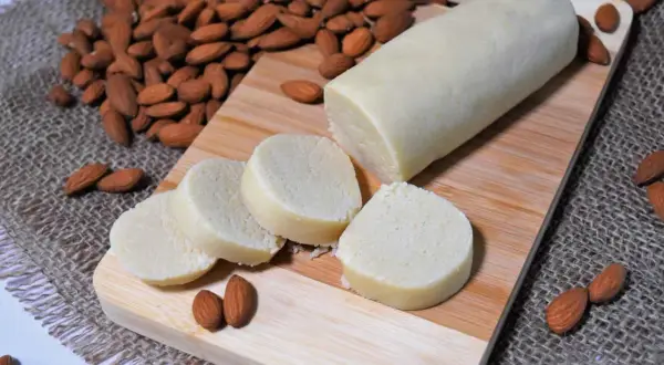 Frisch zubereitetes Marzipan, bereit zum **Marzipan selber machen**. Mandeln und Marzipanrolle auf Holzbrett.