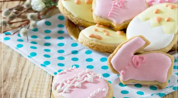 Bunte Osterkekse, ein einfaches Rezept für den Frühling. Hasen, Eier und Blumen auf einem Tupf-Tuch.