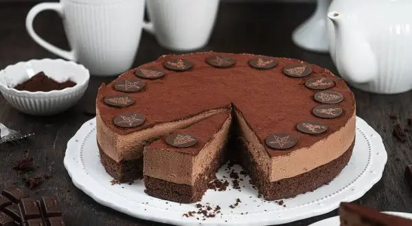 Eine köstliche Schoko Torte, bestäubt mit Kakao und verziert mit Schokoladen-Anis-Motiven, wartet auf Genießer.