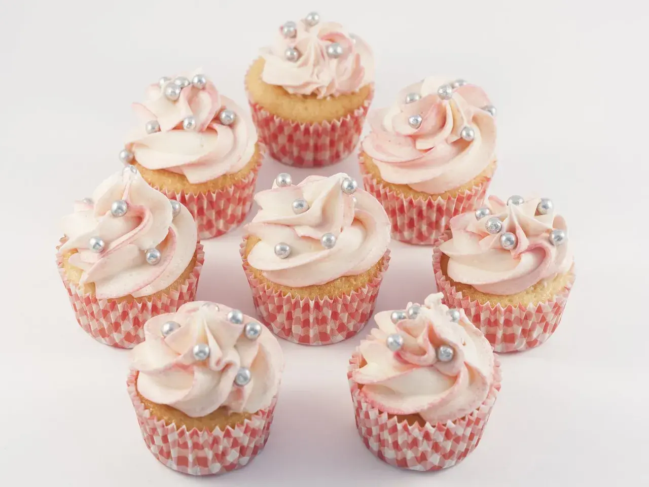 Mini Muffins mit zartrosa Frosting und silbernen Perlen, perfekt für ein mini muffins rezept.