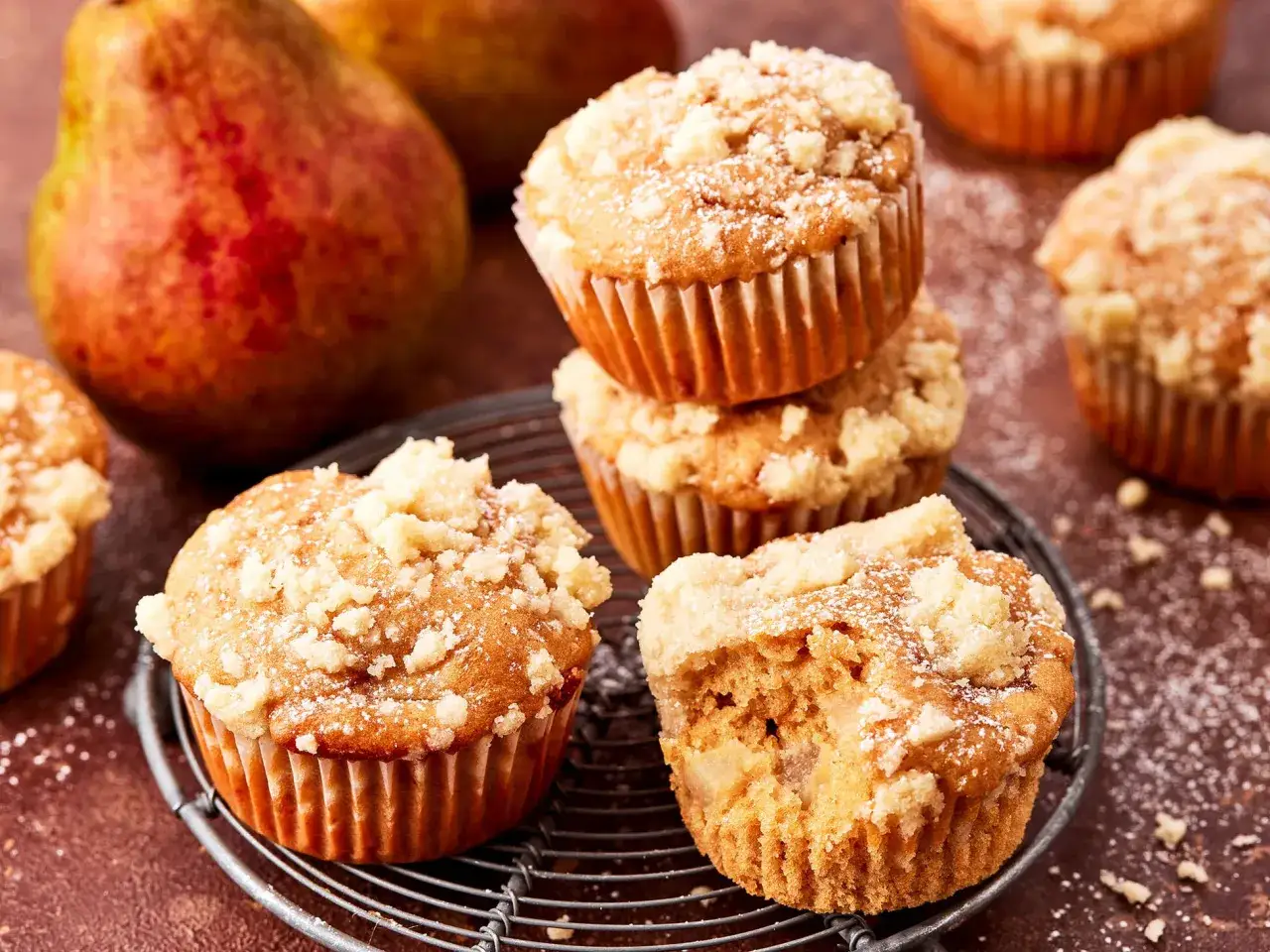 Saftige Birnenmuffins mit Streuseln, ein köstliches Muffins Rezept. Daneben liegen frische Birnen.
