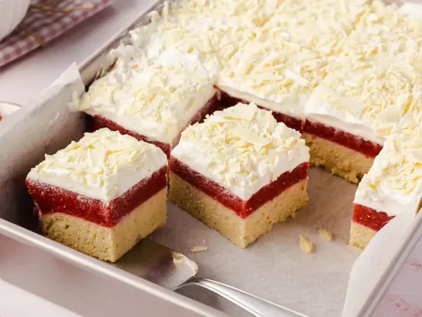 Schneeweiße Sahne und rote Fruchtschicht auf hellem Boden – dieser Frau Holle Kuchen sieht aus wie frisch aus dem Märchen!