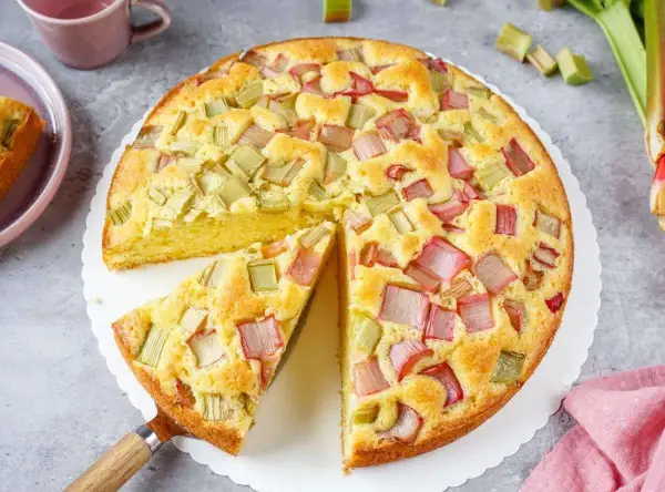 Ein saftiger, schneller Rhabarberkuchen mit vielen roten und grünen Rhabarberstücken, bereit zum Genießen.